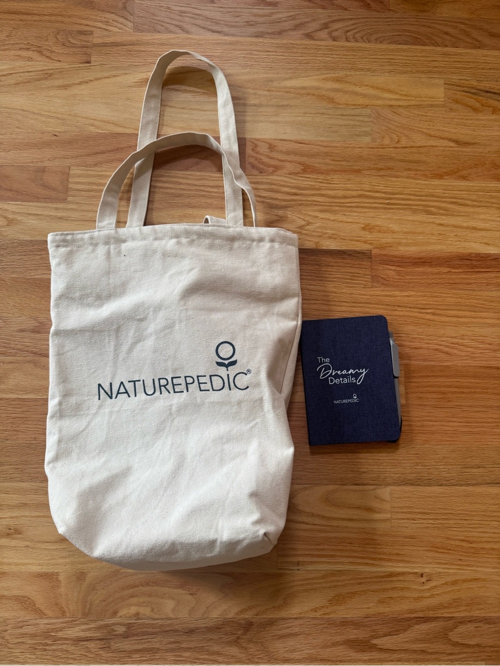 Naturepedic Cream Canvas Tote Bag with notebook and pen